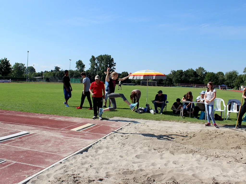Weitsprunganlage mit wartenden Gruppen.